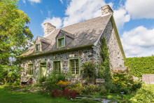 Exterior View Of Idyllic Stone Cottage With Pretty Garden In Canada.