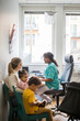 © Maskot - Smiling pediatrician talking to mother while children sitting in clinic
