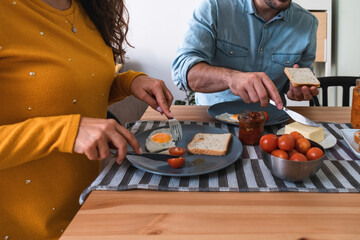 Wall Mural - Close up breakfast table with hands of unrecognizable couple stock photo