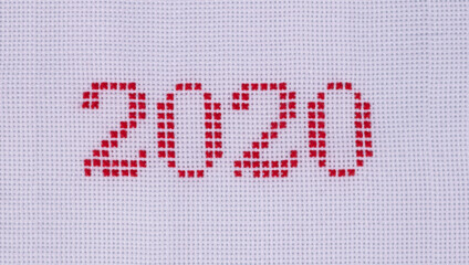 red thread embroidered on white dense fabric numbers, two thousand and twenty, highlighted in close-up.