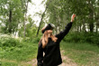 © Maxim - girl stands in the middle of the forest in virtual glasses is surprised stretches her hand to the top