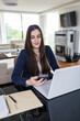 © zphoto83 - Businesswoman using smartphone and laptop at home. Remote working concept.