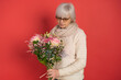 © Ivan - Happy senior woman with bouquet of flowers on color background