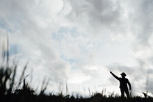 Vintage Hunter Walks. Rifle Hunter Silhouetted In Beautiful Sunset Or Sunrise. Hunter Aiming Rifle In Swamp And Field