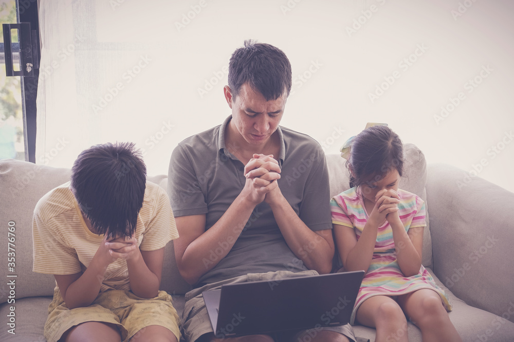 Children praying with father parent with laptop, family and kids worship online together at home, streaming church service, social distancing, lockdown concept - obrazy, fototapety, plakaty 