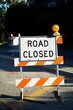 A road closed temporary sign displayed in the middle of the street during sewer construction