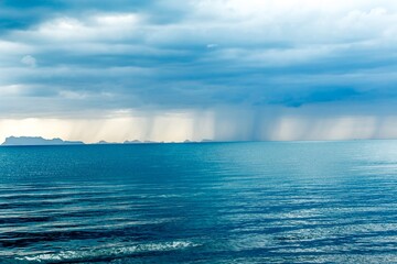 Wall Mural - Rays of light breaking thru rain storm clouds in Asia