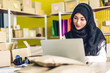 © Art_Photo - Portrait of smiling beautiful muslim owner asian woman freelancer sme business online shopping working on laptop computer with parcel box on table at home - Business online shipping and delivery