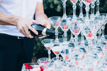 Wall Mural - pyramid of champagne glasses at an outdoor celebration. A glass of champagne with a cherry.