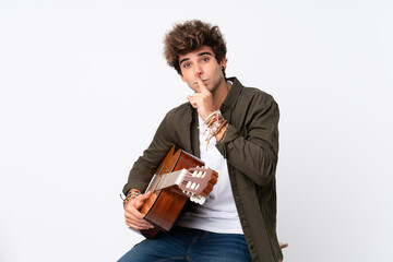 Wall Mural - Young caucasian man with guitar over isolated white background doing silence gesture