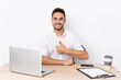 © luismolinero - Young business man with a mobile phone in a workplace giving a thumbs up gesture