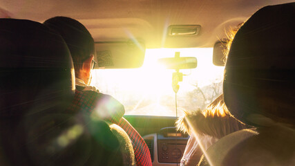 The man and the woman in the car rush towards to the dazzling sun