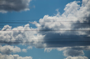 Fluffy clouds cover the summer blue sky