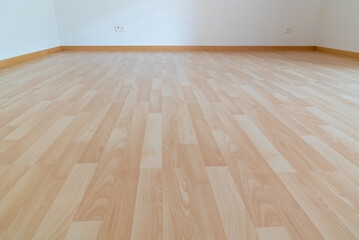 low angle horizontal view of new wooden parquet flooring in a bright light and white apartment room