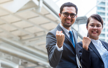 Asian businessman and businesswoman raise up hand for victory.  Business success concept with copy space.