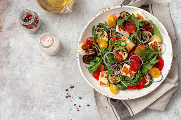 fresh vegetable salad with arugula, grilled vegetables, sherry tomatoes and halloumi cheese.healthy 