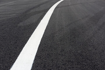 Closeup of white paint line on black asphalt road