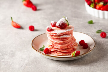 Stack of pink pancakes with strawberry. Pink colourful pancakes with berries. Breakfast