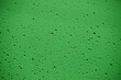 Krople wody na szybie okiennej z zielonym tłem w deszczowy dzień 