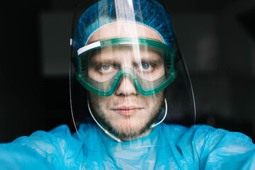 surgeon in medical uniform and protective face shield, specialist glasses. Virus protection concept.