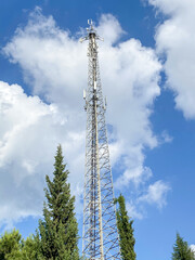 Cellular Base Station or Base Transceiver Station. Telecommunication tower. Wireless Communication Antenna Transmitter. 3G, 4G and 5G Cell Site with blue and cloudy sky.