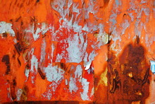 Torn Poster On Red Rusty Metal Wall Texture Background.