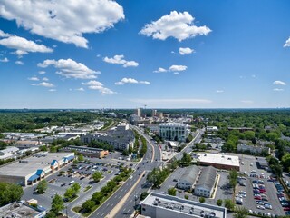 Aerial View of downtown Rockville, Maryland on a sunny day looking south along Hungerford Drive (Route 355). Construction cranes at Rockville Town Center touch the horizon