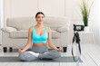 © Prostock-studio - Yoga Blogger Making Video Sitting In Lotus Position At Home
