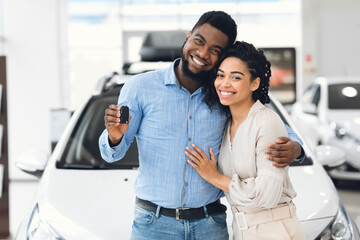 Wall Mural - African Spouses Showing New Vehicle Key To Camera In Dealership