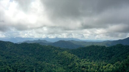 Canvas Print - Aerial drone hyperlapse video of clouds moving fast over mountain forest landscape 