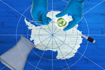 Wall Mural - Antarctica flag on laboratory table. Medical healthcare technologist holding COVID-19 swab collection kit, wearing blue protective gloves, epidemic concept.