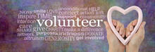 Show Your Love And Volunteer  Word Cloud - Female Hands Holding A Pale Pink Heart Frame Next To A VOLUNTEER Word Cloud On A Multicoloured Rustic Stone Effect  Background
