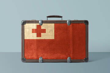 Tonga flag on old vintage leather suitcase with national concept. Retro brown luggage with copy space text.