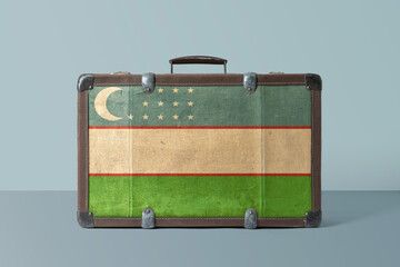 Wall Mural - Uzbekistan flag on old vintage leather suitcase with national concept. Retro brown luggage with copy space text.