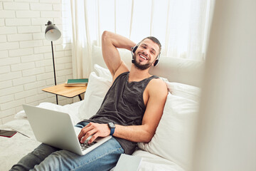 Wall Mural - Cheerful handsome gentleman using laptop in bedroom