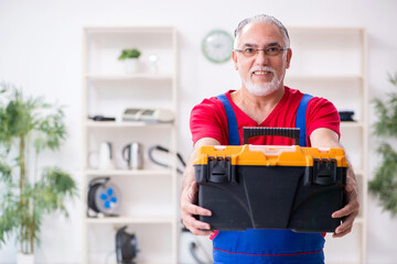 Old male contractor repairing household devices indoors