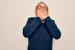 © Krakenimages.com - Senior handsome grey-haired man wearing sweater and glasses over isolated white background shocked covering mouth with hands for mistake. Secret concept.