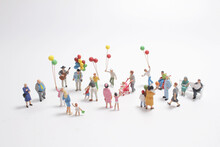 A Mini People With Family Holding Balloon On The Board