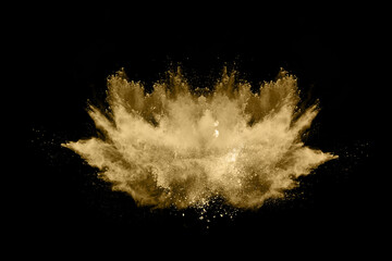 Golden powder explosion on black background. Freeze motion.