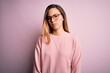 © Krakenimages.com - Beautiful blonde woman with blue eyes wearing sweater and glasses over pink background skeptic and nervous, frowning upset because of problem. Negative person.