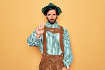 Wall Mural - Young handsome man wearing tratidional german octoberfest custome for Germany festival Pointing with finger up and angry expression, showing no gesture