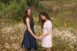 © el_caro - Two girls standing in field on nature and holding hands