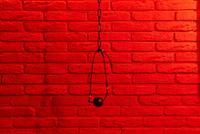 Black Ball Gag In Mouth On Red Brick Wall