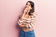 © Krakenimages.com - Young beautiful girl wearing casual striped t shirt smiling looking confident at the camera with crossed arms and hand on chin. thinking positive.