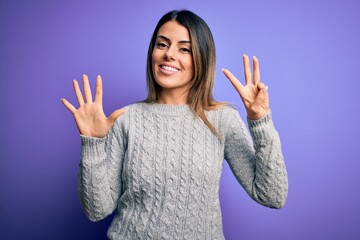 Sticker - Young beautiful woman wearing casual sweater standing over isolated purple background showing and pointing up with fingers number eight while smiling confident and happy.