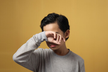 Wall Mural - Little Asian boy student wearing grey shirt crying hard, sadness or bullied concept