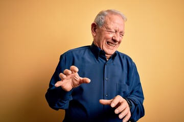 Poster - Grey haired senior man wearing casual blue shirt standing over yellow background disgusted expression, displeased and fearful doing disgust face because aversion reaction.