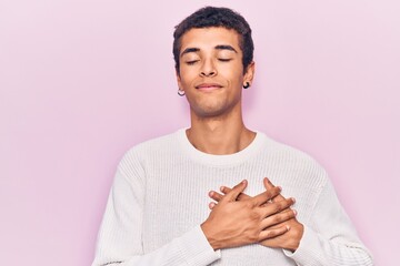 Sticker - Young african amercian man wearing casual clothes smiling with hands on chest, eyes closed with grateful gesture on face. health concept.