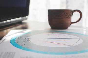 Wall Mural - Workplace of a modern astrologer. A cup of aromatic coffee on the table.