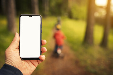 mockup phone image on the blur background of walking children in the forest